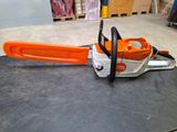 an orange and white chainsaw sitting on top of a table