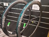 Trois vélos sont exposés dans un magasin de vélos : l'un est noir et l'autre est bleu.
