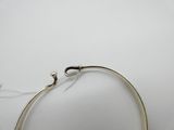 une image représentant un bracelet en argent muni d'un fermoir, posé sur une surface blanche