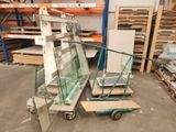 Plusieurs morceaux de verre sont empilés sur un chariot dans un entrepôt