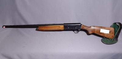 a rifle that is sitting on a table with a white background
