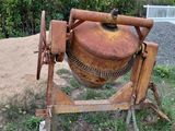 a cement mixer that is sitting in the grass