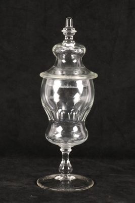 a clear glass jar with a lid on a black background