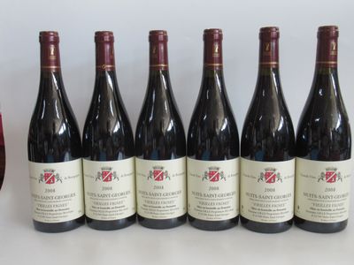 six bouteilles de vin rouge sont posées à côté d'un verre de vin rouge