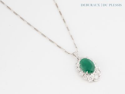 a close up of a necklace with a green stone on it