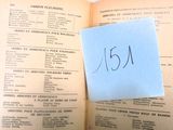 un livre ouvert sur lequel est posé un morceau de papier auquel est attachée une note