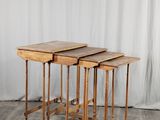 trois tables en bois posées sur un parquet, à côté d'un rideau blanc