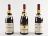 three bottles of wine are lined up on a white surface