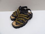 black and yellow sandals with braid straps on top of a white surface