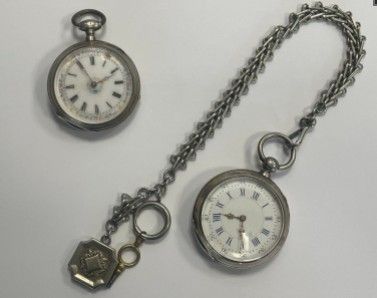 two different types of pocket watches on a table