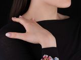 La femme porte un t-shirt noir et une paire de boucles d'oreilles.