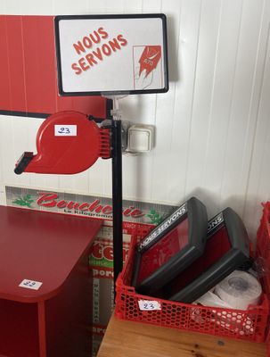 une table rouge sur laquelle est posé un panneau, à côté d'une chaise rouge