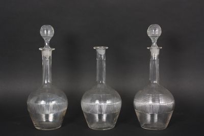 three clear glass vases sitting next to each other on a black surface