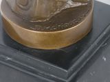 a bronze statue of a man riding a horse on a horse drawn carriage