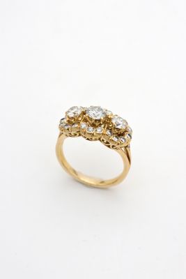 a close up of a gold ring with three diamonds on it