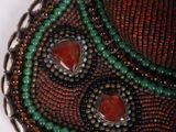 beaded necklace with red, green, and brown beads