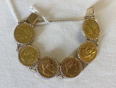 an image of a gold coin bracelet on a white cloth