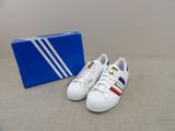 Chaussures adidas Superstar avec leur boîte, posée par terre