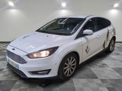 La Ford Focus blanche est garée dans une pièce dont le sol est à carreaux.