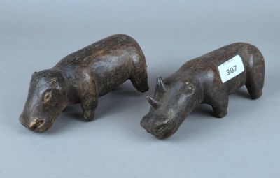 paire de rhinocéros sculptés en bois sur fond gris, avec étiquette de prix