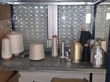 many rolls of thread on a shelf in a room