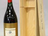 une bouteille de vin dans un coffret en bois à côté d'une bouteille de vin
