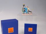 une petite figurine représentant un homme à moto, dans une boîte bleue