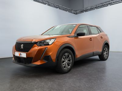 une voiture orange garée dans une grande pièce aux murs blancs