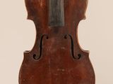 un vieux violon posé sur une surface blanche