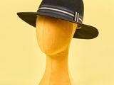 chapeau posé sur une tête de mannequin, sur fond jaune