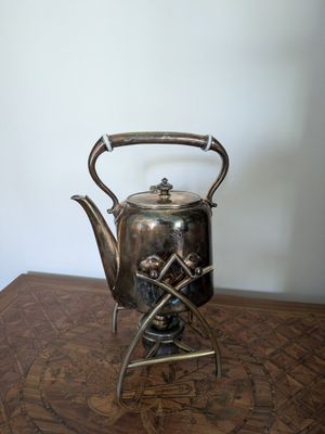 une théière en argent posée sur une table en bois