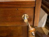 a wooden desk with a drawer on it and a pair of scissors on the desk