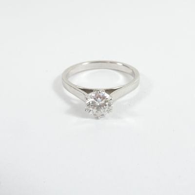 a close up of a diamond ring on a white surface