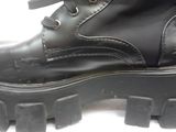 a close up of a pair of black boots on a white surface