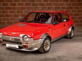 a red car that is parked in front of a brick wall