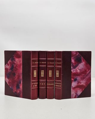 Les trois livres sont alignés les uns à côté des autres sur une surface blanche.