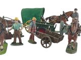 trois figurines représentant un homme et un cheval tirant un chariot couvert