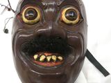 un masque marron avec un sourire sur le visage