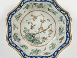 une assiette bleue et blanche ornée d'un oiseau et de fleurs