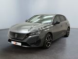 La voiture grise est garée dans une grande pièce au sol noir.