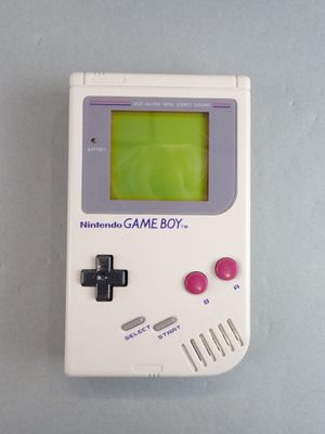 une vieille Game Boy à écran vert posée sur une table