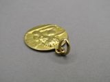 a close up of a gold coin with a face on it