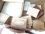 a suitcase full of old books and papers on the floor