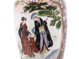a vase with a painting on it that is sitting on a table