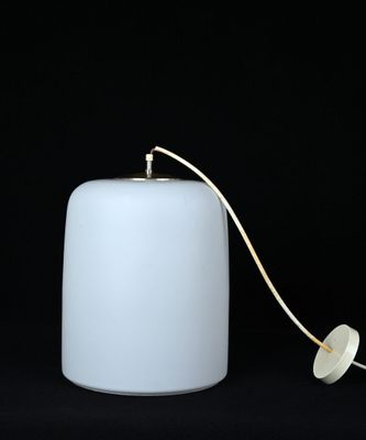 une bougie blanche à laquelle est attachée une ficelle, sur fond noir