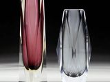 three different colored glass vases sitting next to each other on a table