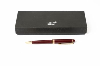 un stylo posé devant une boîte noire sur une surface blanche