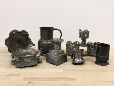 a lot of silver items sitting on a wooden table