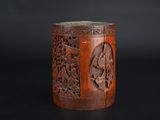 un vieux vase en bois orné de sculptures sur un fond noir