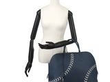 a mannequin mannequin holding a blue bag with white stitching on it